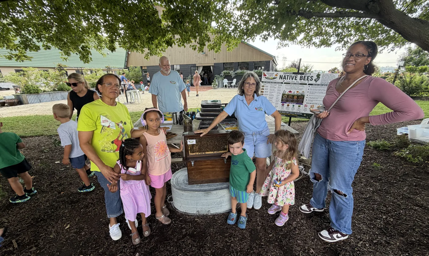 A family standing together at the observation hive