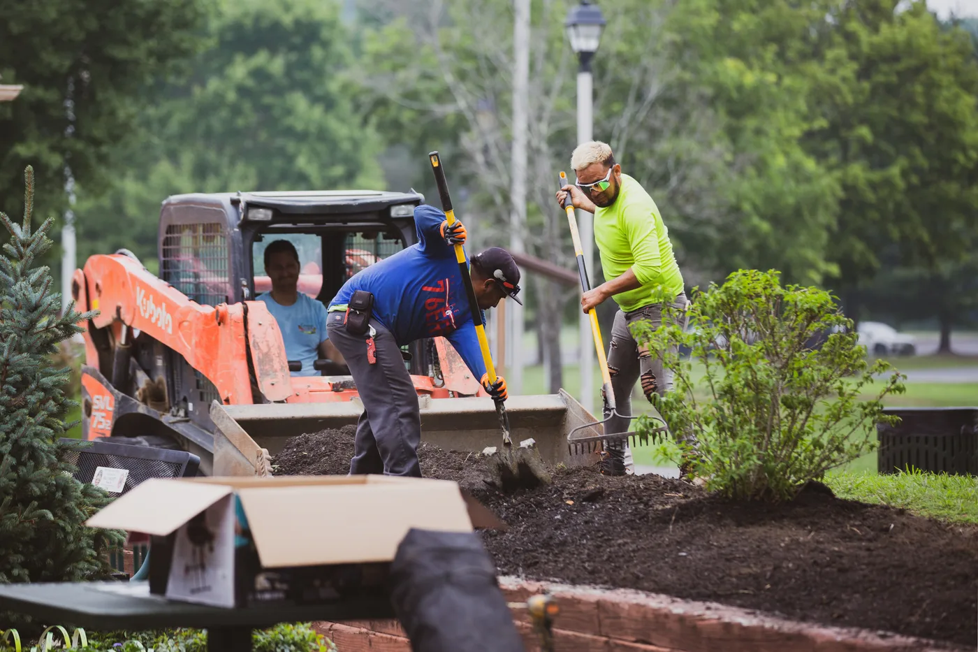 The crew working around the track loader as fresh soil goes into the beds
